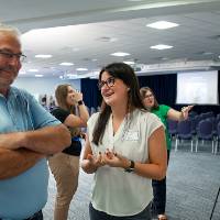Scholar giving poster presentation to a guest.
